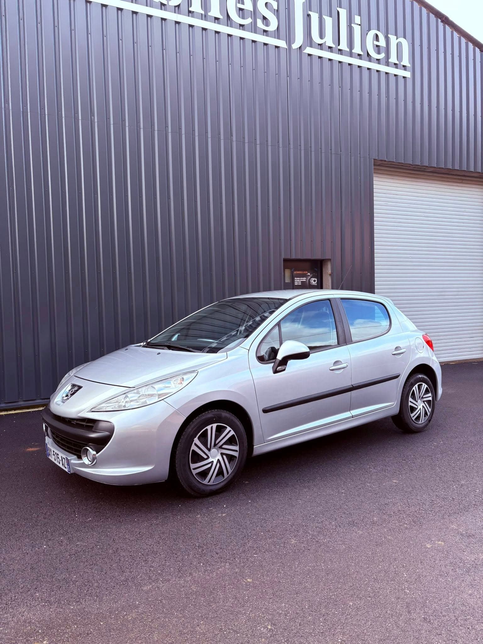 Peugeot 207 grise devant le garage